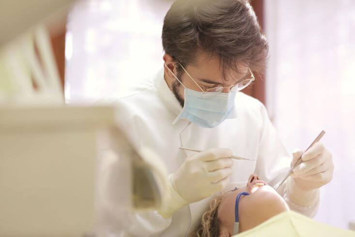 dentista mexendo na boca da paciente.