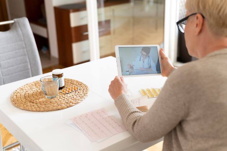senhora fazendo consulta de telemedicina pelo tablet.